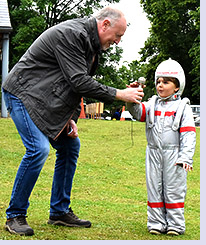 Richard Maryon passing microphone to spaceman Rory for official fete-opening